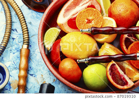 Smoking hookah with citrus fruits. 87019310