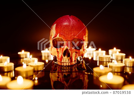 Blood stained skull against dark background closeup Blood stained skull against dark background closeup 87019538