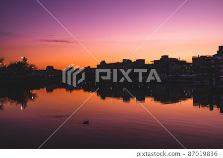 The silhouette of the city after sunset and the city reflecting on the canal 87019836