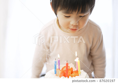 亞洲男孩吹滅生日蛋糕上的蠟燭 87020197