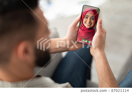 Arab man using modern app on smartphone to videochatting with his wife 87021114