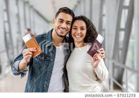 Happy Travellers. Young Arab Couple With Passports And Tickets Posing At Airport 87021258