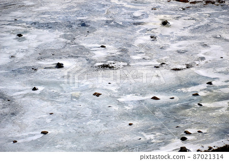 Winter background. The ice and rocks. Top view of the river. Nature draws. 87021314