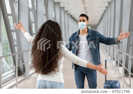 Happy Arab Guy Wearing Medical Mask Meeting Girlfriend In Airport After Arrival Happy Arab Guy Wearing Medical Mask Meeting Girlfriend In Airport After Arrival 87021796