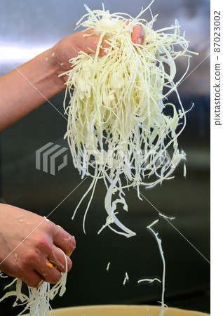 Adding carrots to cabbage, the process of cooking sauerkraut, finely chopped cabbage and carrots. 87023002