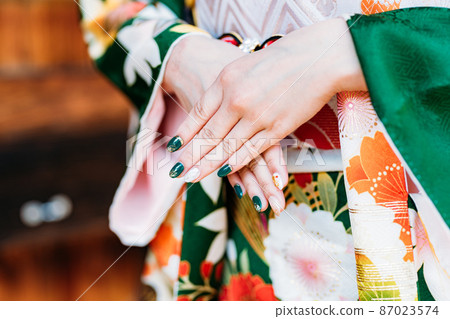 A woman wearing a beautiful nail and kimono 87023574