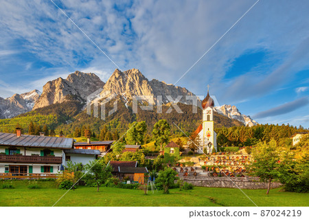 Zugspitze peak and Alps mountain range with small church, Garmisch Partenkirchen, Germany 87024219