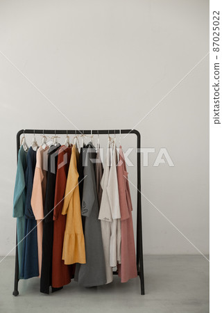 Black minimalistic rack with eco linen clothes on white background. Black minimalistic rack with eco linen clothes on white background. 87025022