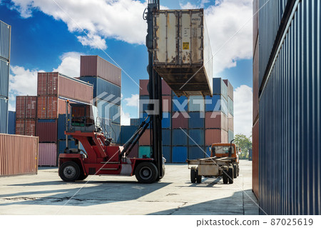 Crane lifting up container in railroad yard 87025619