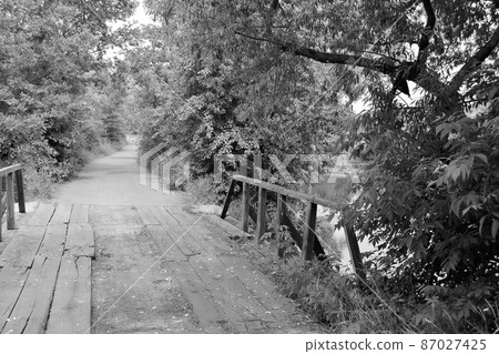 Beautifully standing old wooden bridge over river in colored background 87027425