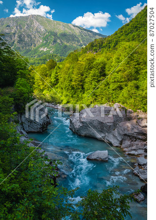 Soca river with rocky shoreline in the forest, Kobarid, Slovenia Soca river with rocky shoreline in the forest, Kobarid, Slovenia 87027504