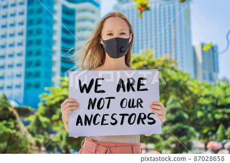 Woman holds a poster with an inscription - we are not our ancestors 87028658