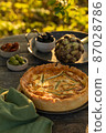 Golden organic healthy crispy pie with artichokes, dried tomatoes and olives on the table 87028786