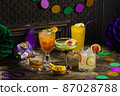 Alcoholic cocktails, Mardi Gras decoration on dark background 87028788