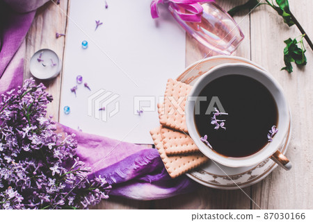 Morning cup of tee, cookies, and lilac flower on wooden table from above. Beautiful breakfast. Flat lay style with copy space Morning cup of tee, cookies, and lilac flower on wooden table from above. Beautiful breakfast. Flat lay style with copy space 87030166