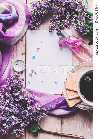 Morning cup of tee, cookies, and lilac flower on wooden table from above. Beautiful breakfast. Flat lay style with copy space Morning cup of tee, cookies, and lilac flower on wooden table from above. Beautiful breakfast. Flat lay style with copy space 87030167
