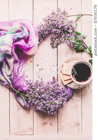 Morning cup of tee, cookies, and lilac flower on wooden table from above. Beautiful breakfast. Flat lay style with copy space Morning cup of tee, cookies, and lilac flower on wooden table from above. Beautiful breakfast. Flat lay style with copy space 87030176