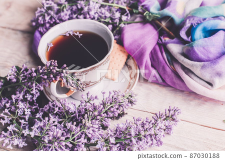 Morning cup of tee, cookies, and lilac flower on wooden table from above. Beautiful breakfast. Flat lay style with copy space Morning cup of tee, cookies, and lilac flower on wooden table from above. Beautiful breakfast. Flat lay style with copy space 87030188