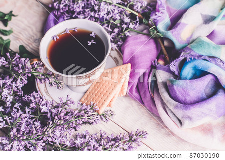 Morning cup of tee, cookies, and lilac flower on wooden table from above. Beautiful breakfast. Flat lay style with copy space Morning cup of tee, cookies, and lilac flower on wooden table from above. Beautiful breakfast. Flat lay style with copy space 87030190