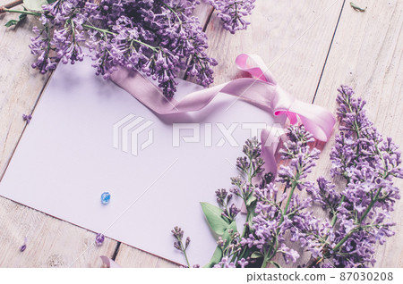 Spring flowers. Lilac flowers on white wooden background. Top view, flat lay with copy space Spring flowers. Lilac flowers on white wooden background. Top view, flat lay with copy space 87030208