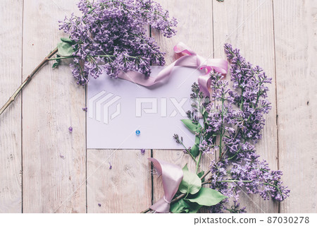 Spring flowers. Lilac flowers on white wooden background. Top view, flat lay with copy space 87030278