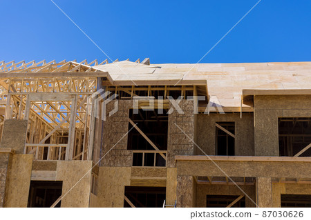 The timber frame beam framework house stick built home under construction new build with wooden truss 87030626