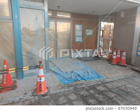 The store on the first floor that is being cured with vinyl sheets 87030949