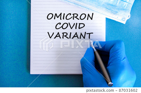 New covid-19 omicron variant strain symbol. Hand in blue glove with white note. Concept words Omicron covid variant. Metalic pen. Medical and COVID-19 omicron variant strain concept. Copy space. New covid-19 omicron variant strain symbol. Hand in blue glove with white note. Concept words Omicron covid variant. Metalic pen. Medical and COVID-19 omicron variant strain concept. Copy space. 87031602