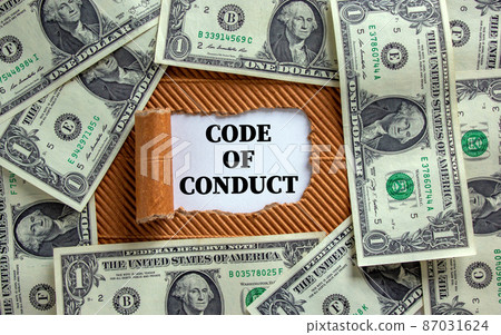 Code of conduct symbol. Words 'Code of conduct' appearing behind torn brown paper. Beautiful background from dollar bills. Business, code of conduct concept, copy space. Code of conduct symbol. Words 'Code of conduct' appearing behind torn brown paper. Beautiful background from dollar bills. Business, code of conduct concept, copy space. 87031624