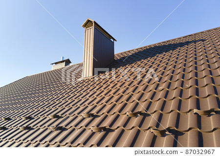 Closeup snow guard for safety in winter on house roof top covered with steel shingles. Tiled covering of building 87032967