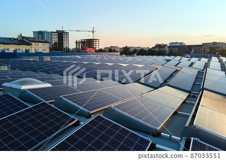Blue photovoltaic solar panels mounted on building roof for producing clean ecological electricity at sunset. Production of renewable energy concept 87033551