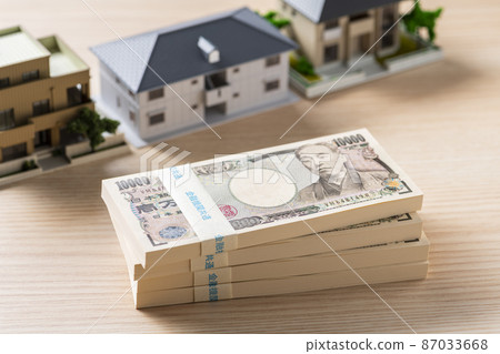 A bundle of bills (money) and a model house 87033668