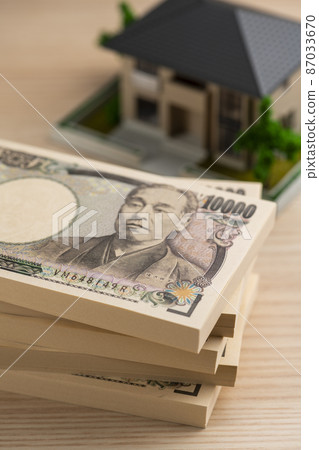 A bundle of bills (money) and a model house 87033670