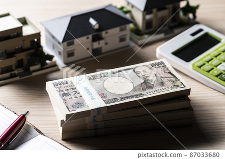 A bundle of bills (money) and a model house 87033680