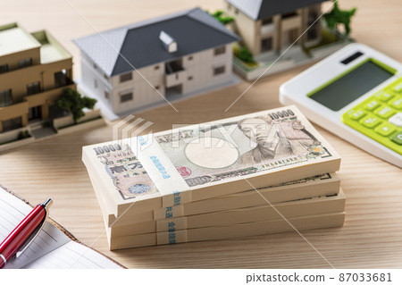 A bundle of bills (money) and a model house 87033681