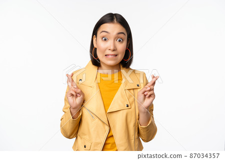 Portrait of excited asian woman looks hopeful, wishing, praying or begging, waiting for news, standing over white background, smiling enthusiastic Portrait of excited asian woman looks hopeful, wishing, praying or begging, waiting for news, standing over white background, smiling enthusiastic 87034357