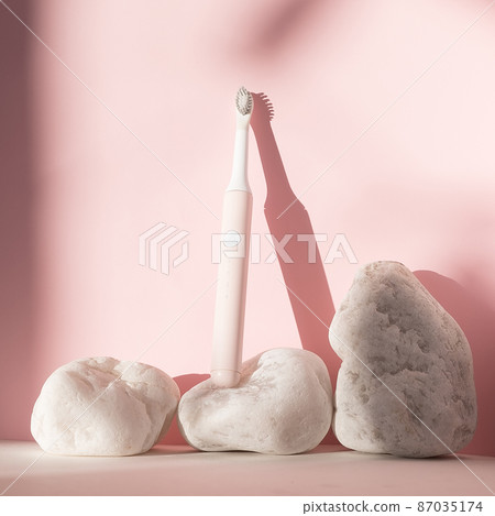 New modern ultrasonic toothbrush. Dental care supplies with white stones on pink pastel background. Oral hygiene, dental and gum health, healthy teeth. Dental products Ultrasonic vibration toothbrush. New modern ultrasonic toothbrush. Dental care supplies with white stones on pink pastel background. Oral hygiene, dental and gum health, healthy teeth. Dental products Ultrasonic vibration toothbrush. 87035174