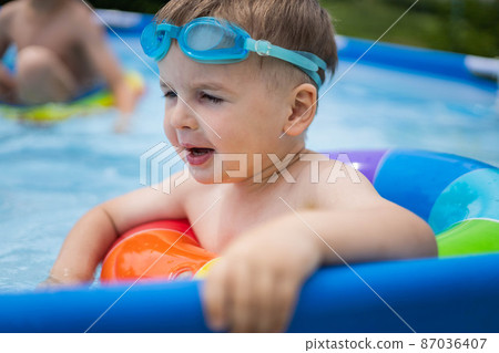 Little boy toddler in the pool with bright swimming circles. Little boy toddler in the pool with bright swimming circles. 87036407