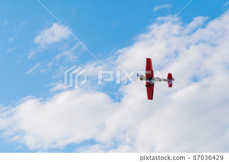 Light aircraft flying in blue sky and doing stunts Light aircraft flying in blue sky and doing stunts 87036429