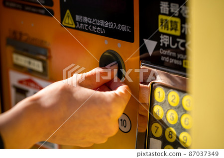 A woman who pays for coin parking Coin parking 87037349