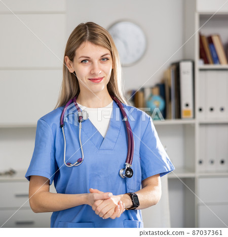 nurse standing in medical office with clipboard 87037361
