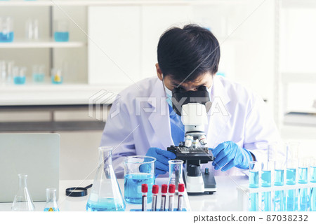 Scientist man look into Microscope research in science laboratory. Asian scientist looking equipment laboratory chemistry labs. Covid-19 coronavirus biochemistry research experiment vaccine concept 87038232