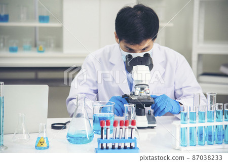 Scientist man look into Microscope research in science laboratory. Asian scientist looking equipment laboratory chemistry labs. Covid-19 coronavirus biochemistry research experiment vaccine concept Scientist man look into Microscope research in science laboratory. Asian scientist looking equipment laboratory chemistry labs. Covid-19 coronavirus biochemistry research experiment vaccine concept 87038233