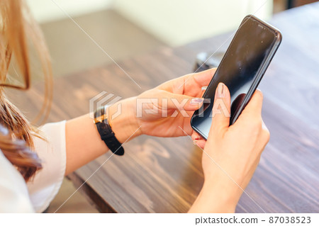 Female who operates a mobile phone cell phone 87038523