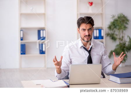 Young male employee working in the office Young male employee working in the office 87038989