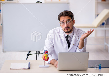 Young male doctor cardiologist sitting in the classroom Young male doctor cardiologist sitting in the classroom 87039092