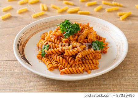 spirali or spiral pasta with tomato sauce 87039496