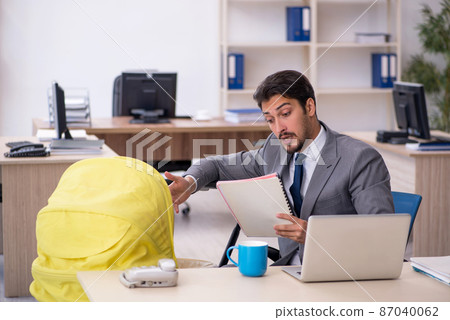 Young male employee looking after new born at workplace Young male employee looking after new born at workplace 87040062