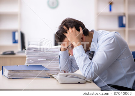 Young male employee working in the office Young male employee working in the office 87040063
