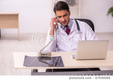Young male doctor working in the clinic Young male doctor working in the clinic 87040066